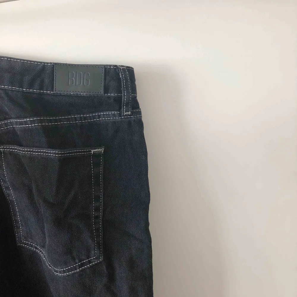 Mått- W32 L32. Snygga svarta utsvängda jeans med vita sömmar från Urban Outfitters. Korta i längden. . Jeans & Byxor.