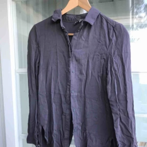  - Lila-grå denimskjorta med slits i ryggen från HM, aldrig använd då den var fel storlek för mig. Rak smal passform, ej stretch. 