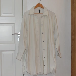 Skjortklänning  - En längre skjorta som kan användas öppen och stängd. Den är i storlek m, skulle kunna passa L, eller vara oversized på mindre storlekar. Väldigt fint skick, bara provad. Den kan knytas i midjan med tillhörande band. Skicka om du vill ha fler bilder. 