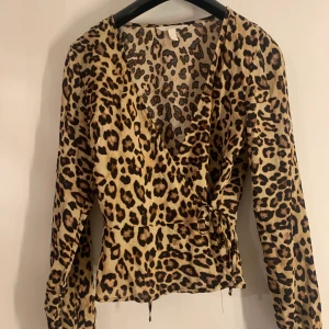 Leoparblus från H&M aldrig använd - Aldrig använd omlottblus från H&M i strl 32, men i och med att man knyter den är den mer som en 32-36. 