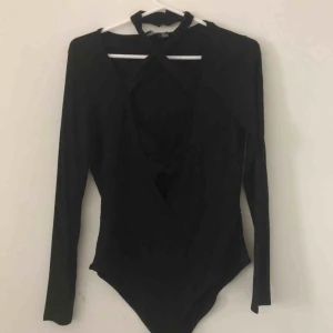  - Oanvänd body, svår att ta bild på! Djupt urringad med remsor man knäpper bakom nacken. 