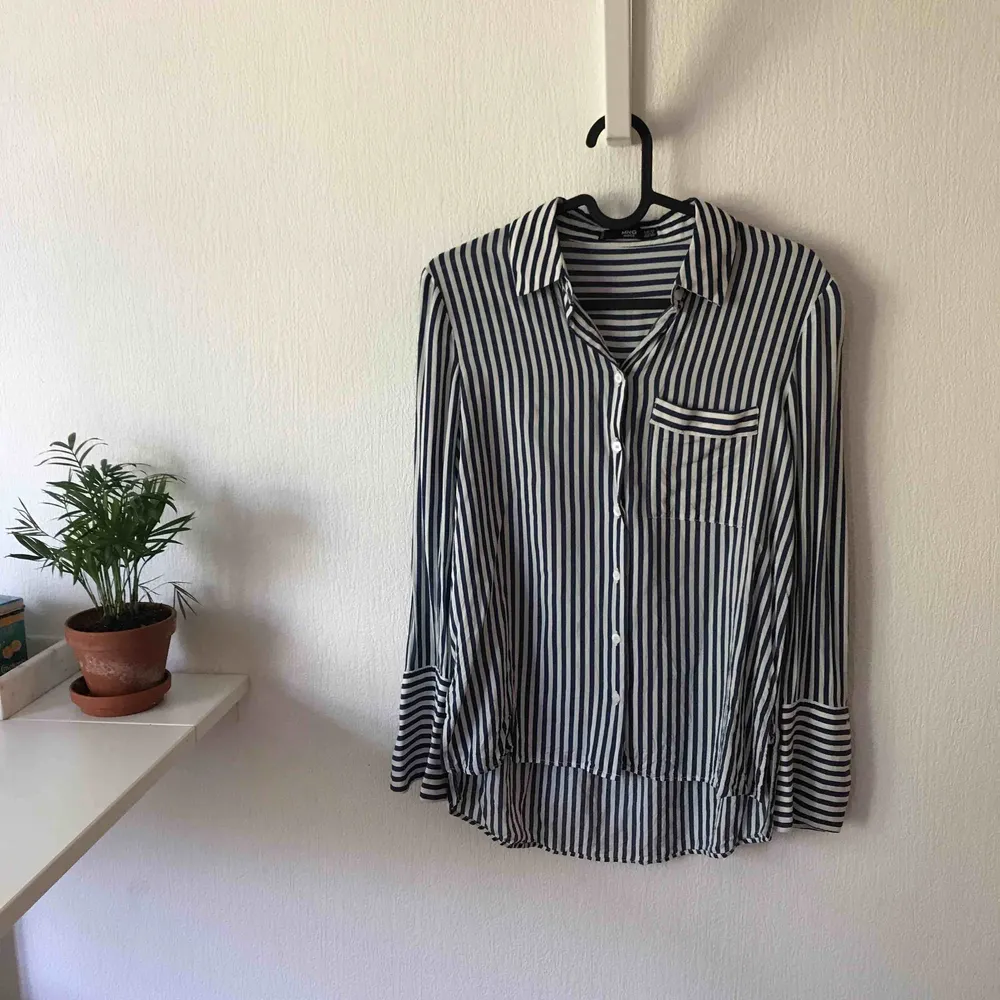 Randig skjorta från Mango med bröstficka (från bildens håll) höger sida. Annorlunda men snygg avslutning på skjortans armar. Använd en gång och är i mycket bra skick. Vid köp tillkommer fraktkostnad.. Skjortor.