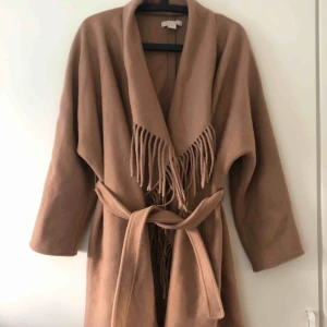  - Jacka med fransar och band i midjan. Oversize, passar upp till XL. 