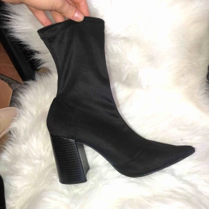  - Boots med spetsig tå i stretch material, tyget är glansigt med svagt randig matt klack  Frakt ingår 