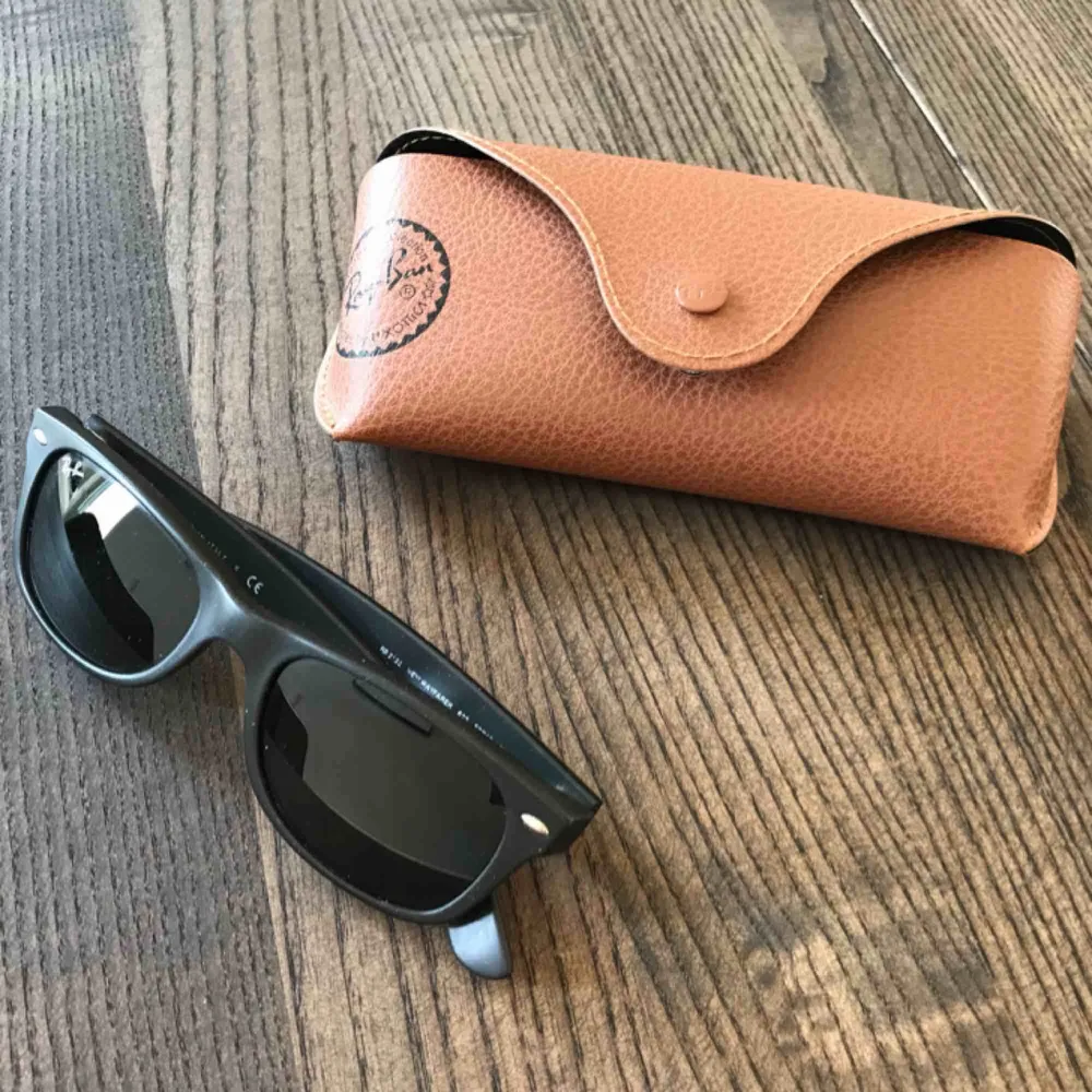 The original Ray Ban RB2132 New Wayfarer sunglasses in black matte colour. Originally bought for 885 SEK. They are used and a little worn few places but barely visible. Very well maintained.. Accessoarer.