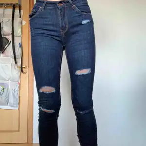 Ett par snygga mörkblåa jeans med slitningar. Endast använda någon enstaka gång, för små för mig och inte min stil längre. Nyskick! Oklart vilken storlek det är men skulle gissa liten 36 eller 34. Jag är S/M och som sagt liite tighta på mig🌸