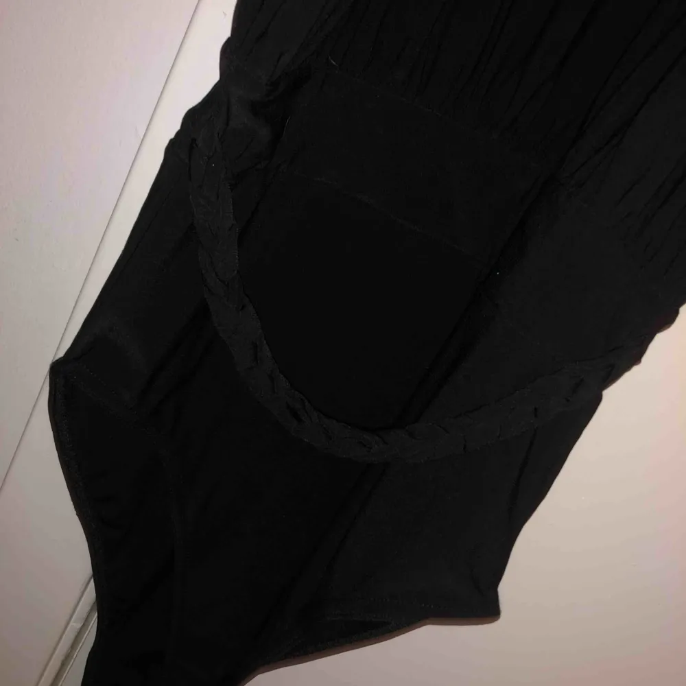 En svart bodysuit med detaljer. Toppar.