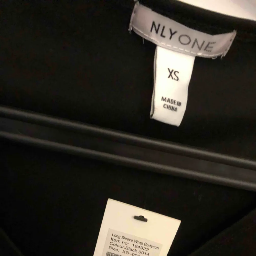En svart ”wrap” klänning från Nelly Aldrig använd. Klänningar.