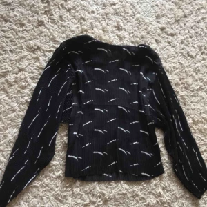  - En svart plisserad blus. Helt oanvänd 