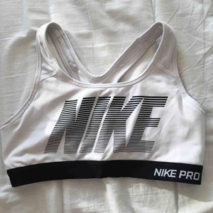  - Vit sport-bh med brottarrygg och stort Nike märke fram. Superskön men är tyvärr för liten för mig. Den är inte mycket använd alls så är i väldigt fint skick. Dock finns inga pads till insidan av bh-n kvar. 