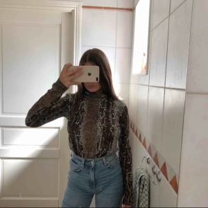  - Långärmad turtlenecktröja med ormmönster från Zara.