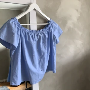 Söt topp från Stradivarius - Söt topp med vita pärlor på, både på fram & baksida. Från Stradivarius, storlek L. Knappt använd & är i bra skick. Priset är inkl frakt 