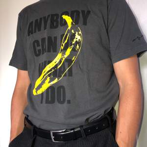 T-Shirt med Andy Warhol/Velvet Underground bananen som tryck med texten ”Anybody can do what I do”. 