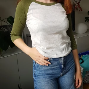 Grön & grå tröja - Grön och grå tröja med halvkorta ärmar. Tröjan är mer grå i verkligheten.