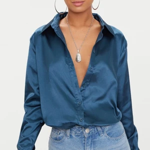 Blå satinskjorta PLT - Blå satinskjorta från Pretty Little Thing. Jättefin och oanvänd, köpt i storlek XS, kvar i originalförpackning.