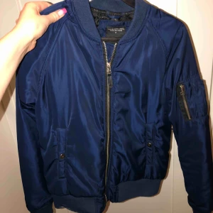  - En fin blå bomberjacka i storlek S. Den är i fint skick och det helt oanvänd ut!