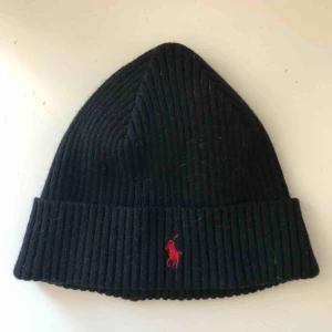  - Svart Ralph Lauren mössa med rött märke. Knappt använd. Betalning via swish. Kan mötas upp i trelleborg, malmö eller lund alternativt fraktas vilket köparen står för.