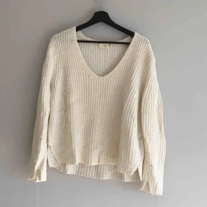  - Vit v-ringad stickad tröja från H&M. Köparen står för frakten!