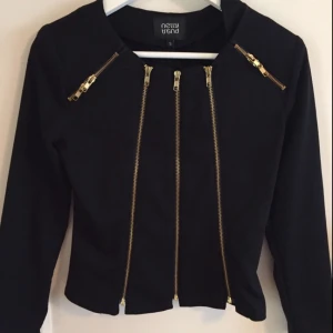  - Jacka/tröja från Nelly trend i storlek small med guld detaljer. Nästintill oanvänd så i väldigt fint skick!