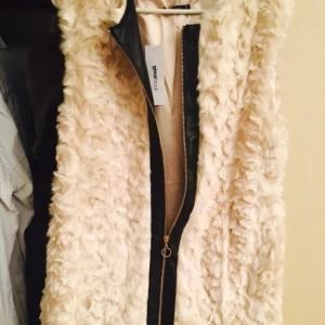  - Vit och svart zip upp pälsväst
