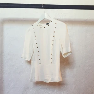  - Fin vit blus från H&M med små guldiga nitdetaljer. Liten i storleken.