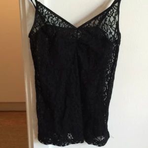 - Spetslinne, svart. Stretchig. Står strl 40 men passar S-M bra.