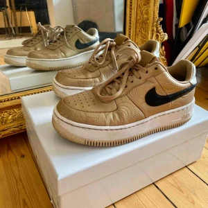  - Jättefina Nike Air Force sneakers i guld!🌟✨ de är jubileumsgåva från året det kvinnliga amerikanska fotbollslaget vann OS💪🥇 nypris 1599kr