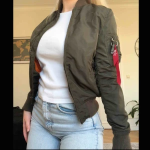  - Militärgrön bomberjacka från Alpha Industries med orange tyg inuti. Orginalpris 1700 kr så det är superbra pris för en jacka i nyskick som knappt är använd