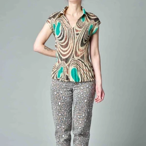  - En krinklad lätt utställd topp med krage och psykedeliskt mönster. Tunn, lätt transparent. Mäter 53 cm mitt fram. Frakt exklusive. 