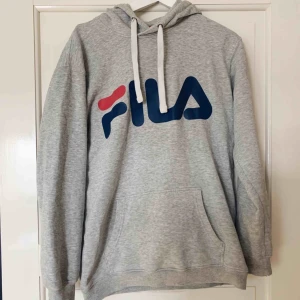  - Hoodie från FILA med stort tryck på bröstet. Justerbar huva med band, bra skick. Fler bilder kan skickas, frakt ingår ej. 