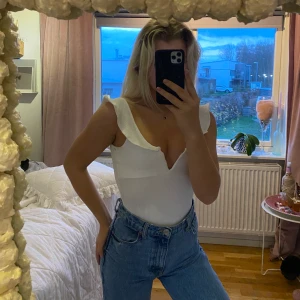 Vit body - Vit body med volanger från ginatricot. Man knäpper med knappar längst ner.