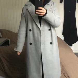 Lång kappa  - En superstilig kappa i lång modell. Fickor på vardera sida och snygga knappdetaljer. Använd fåtal gånger, toppskick!  Ordinarie pris: 700 köparen står för frakten 