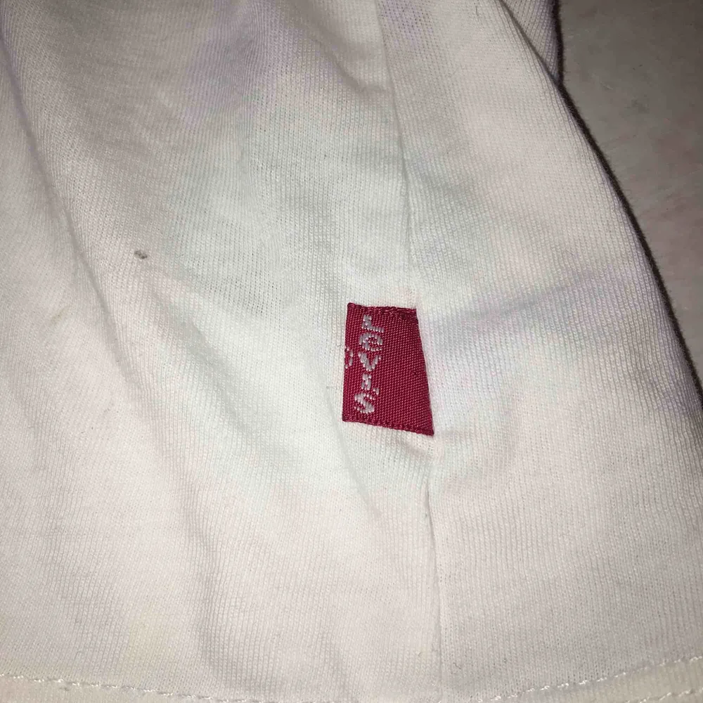 Klassisk vit Levis t-shirt med rött tryck. Storlek XS men passar snarare S, använt skick men inget fel på den alls. Nypris ca 500 kr. T-shirts.
