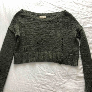  - Militärgrön tröja med slitningar i. Har knappt använt den säljer den på grund av att det inte är min still och den tar plats i min garderob 