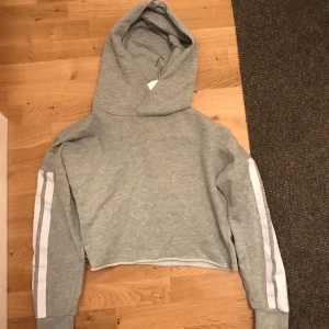 Huvtröja - Grå huvtröja med vita ränder. Lite kortare framtill. 50:- exl frakt.