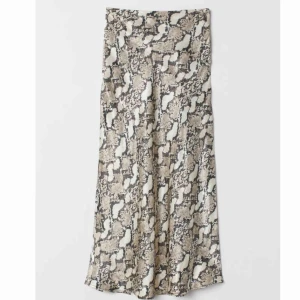  - Beige/grå ormskinnsmönstrad kjol i viskomaterial, liknar siden. Från hm och är använd fåtal gånger. Frakt ingår inte. Lånad bild!!