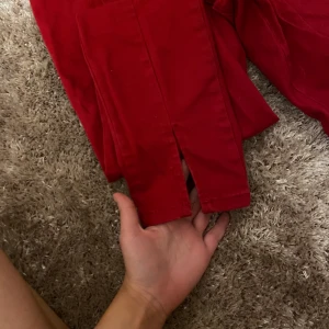 NA-KD jeans strl 38 - Röda jeans med söm och slits på framsidan av byxorna. Strl 38 men passar bättre till en 36a!❤️ (60kr frakt)