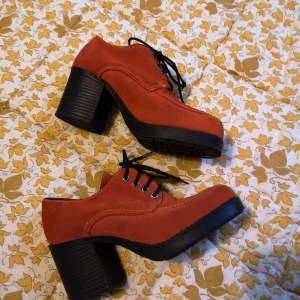 Vintage orangea klackar/kängor - nyskick  - Vintage, rostorangea skor. Fint skick. Väldigt lite använda, finns en mini fläck och slitningar på skosnören. Märkta 36. Passar någon med stl 35 eller 35,5 i skor. Kanske även 36, men absolut inte större än så, jag med 36,5 kan inte ha dom. Klack 7cm