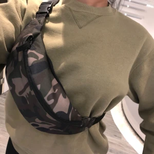  - En supersnygg magväska i armyprint som har 2 fack som går att justera i storlek. Helt ny.