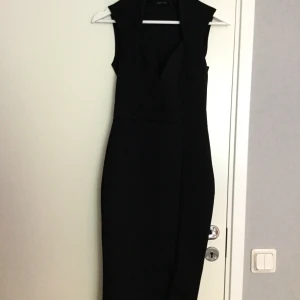  - Svart figursydd, stretchig klänning med djup urringning. I nyskick! Från NLY ONE. Stl.small.