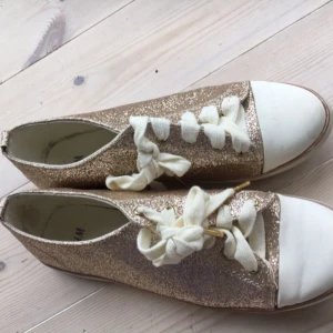  - 🌷Guld glittriga sneakers i storlek 40 från H&M. Sparsamt använda men har en blek fläck på tån av ena skon, så priset kan diskuteras. Hund ingår inte. 🌷
