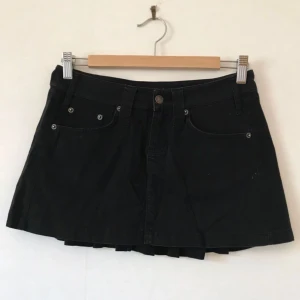  - Supersöt svart kjol i tyg som känns som jeans/sammet, 100% bomull, plissering i bak. Kort och 90/2000-tal på ett göttigt sätt! Fint skick, men litet luddig på bilderna, rollas förstås vid köp.  Kan mötas i Stockholm eller skicka mot fraktkostnad! ✨🌸✨