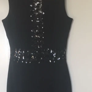  - En lång kläning, tajt, visar former.