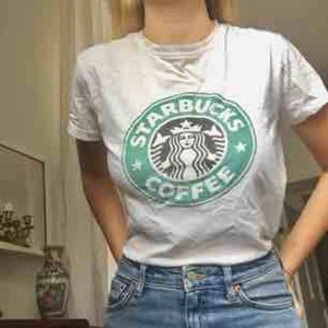  - Starbucks t-shirt köpt i Spanien! Passar XS och S beroende på hur man vill att den ska sitta. Mjukt tyg och trycket försvinner ej i tvätten. Litet hål i ena armhålan. Möts i Stockholm!