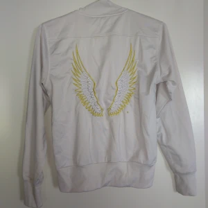  - Träningsjacka från Red Label Carlings. Två fickor framtill, tryck av vingar baktill. Gula detaljer. Gratis frakt!