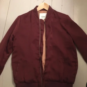 - Tunn bomberjacka vinröd med orange innefoder, från carlings, storlek 36