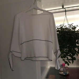  - Vit blus med svarta ränder, och knytbara ärmar. Aldrig använd, köpt på Zara.