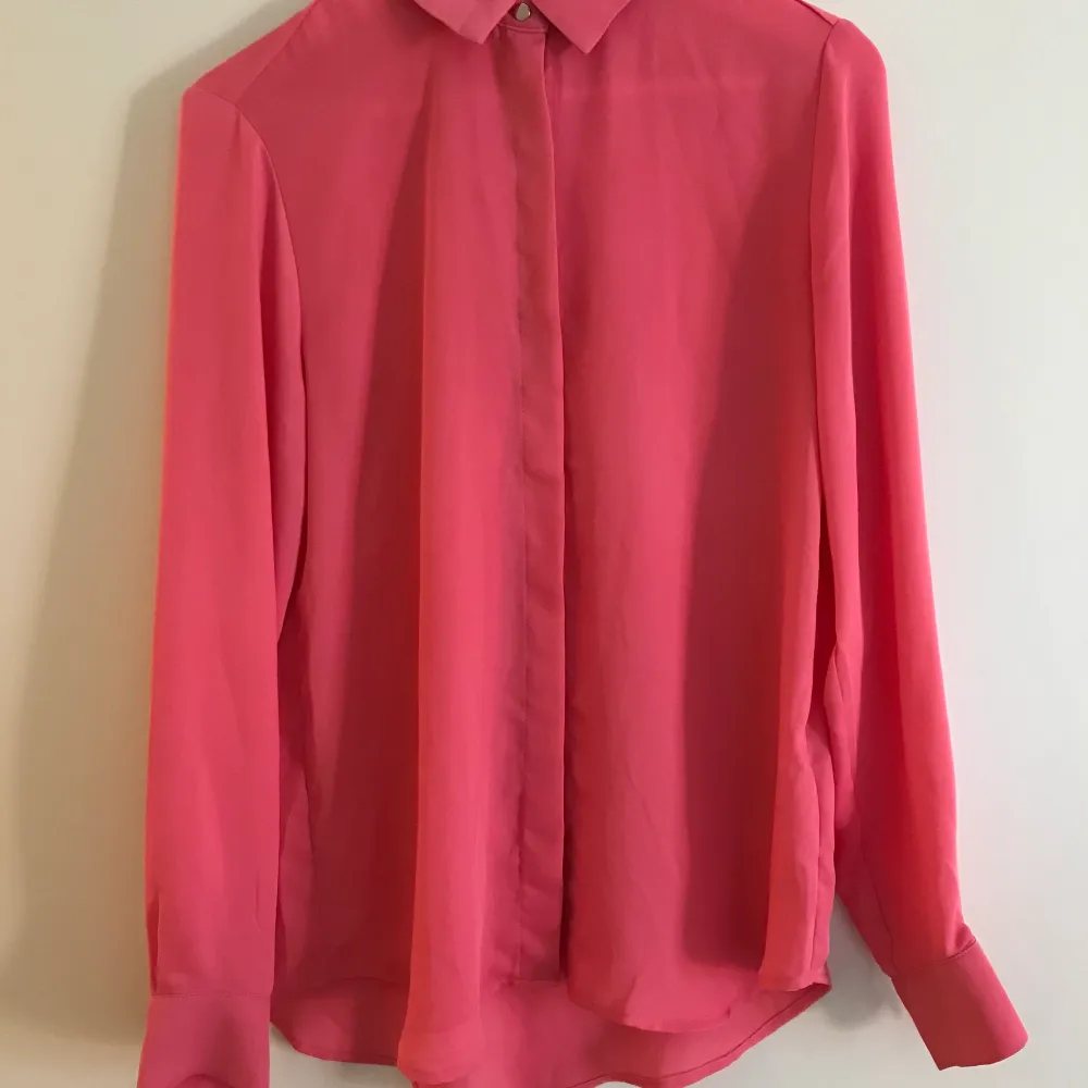 En snygg härligt ceriserosa skjorta. Det är 100% polyester vilket gör att materialet inte skrynklar sig. Ser som ny ut och använd ett fåtal ggr. Fraktkostnad 44kr Postnord . Skjortor.