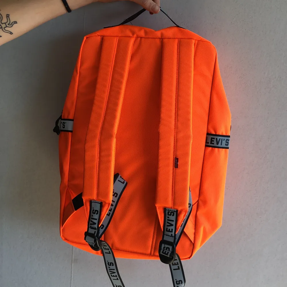 Oanvänd neon-orange backpack från Levis. 25L med laptopficka inuti.. Väskor.