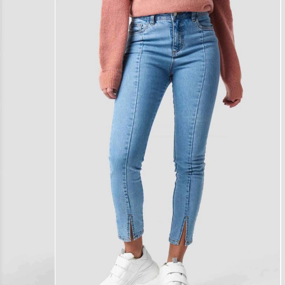 Snygga jeans från NA-KD med slits fram. Säljer pga för små för mig. Använda 2 gånger så de är i mycket bra skick. Lite annorlunda färg i verkligheten (se bild 3). . Jeans & Byxor.